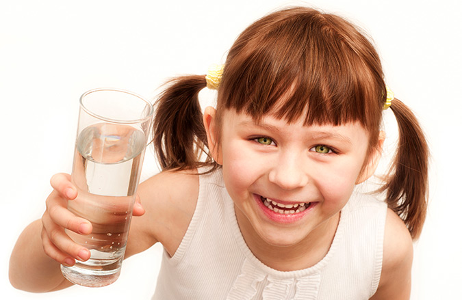 Girl holding up a glass of water