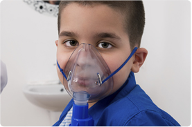 a boy receives treatment for asthma with a nebulizer