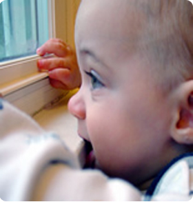 a boy chews on a window sill